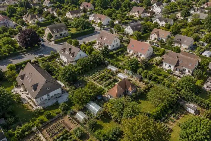 Vue aérienne de quartier résidentiel avec jardins et potagers